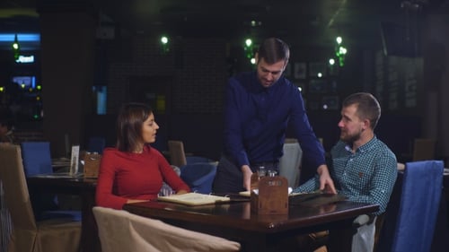 Cheerful Couple with Menu in a Restaurant Making Order