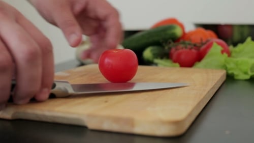 Cutting Fresh Tomato on Cutting Board Close Up