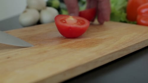 Tomato Slicing Preparation on Wooden Cutting Board