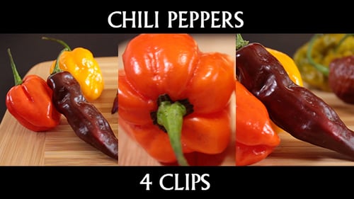 Assorted colorful chili peppers displayed on wooden board