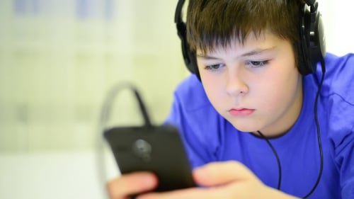 Boy With Headphones Using Smartphone, Close Up