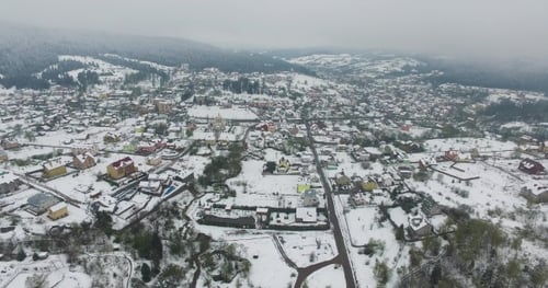 Aerial View. Snowy Village in the Valley of the Mountains