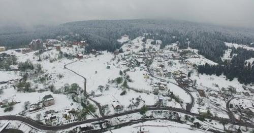 Aerial View. Snow Covered Village on a Hilly Terrain