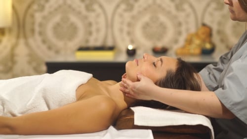 Woman Receiving a Facial Massage in Spa