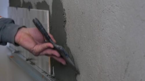 Applying Gray Adhesive on Wall for Tile Install