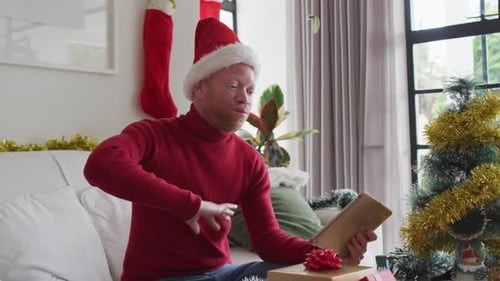 Man in Santa Hat Video Calling on Tablet