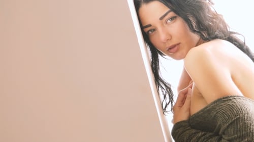 Beautiful Woman Posing Leaning Against a Wall