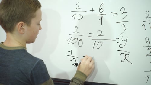 Schoolboy Writing Something on Blank White Board