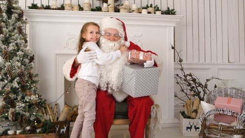 Girl Gives Gift to Santa Claus at Christmas