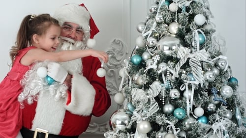 Girl Decorating Christmas Tree with Santa Claus