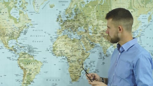 Man Points to Map in Office