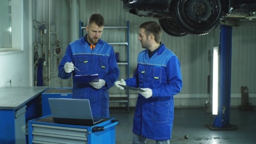 Mechanics Discussing Car Repair with Technology