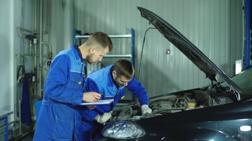 Zwei Mechaniker arbeiten an einem Auto