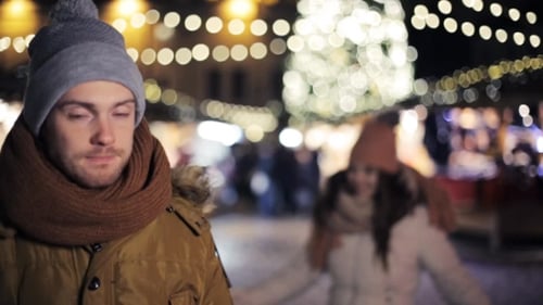 Romantic Couple Laughing at Christmas Market at Night