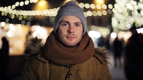 Man Smiling on City Street at Night