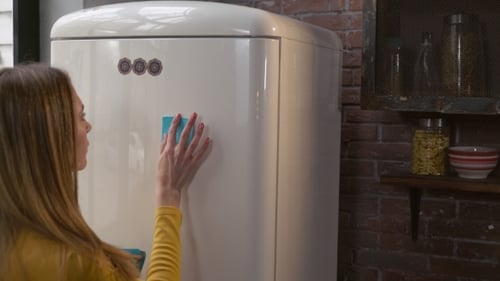 Female Writes Note on Fridge