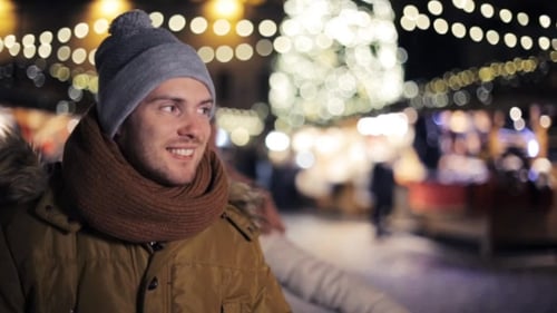 Woman Surprises Man at Christmas Market at Night