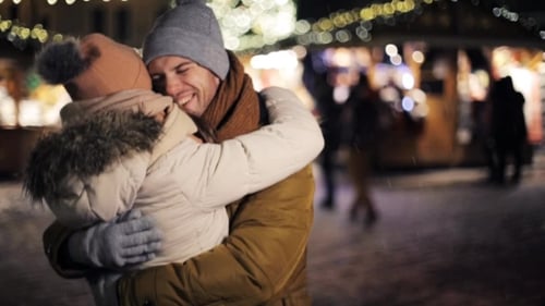 Father and Daughter Embracing at Holiday Market at Night