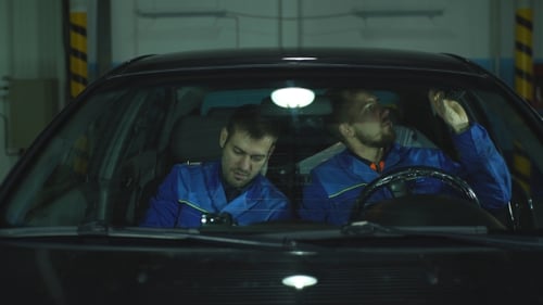 Two Mechanics Discussing Auto Repairs in Car