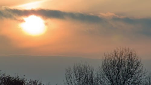 Sonnenuntergang über den Bäumen und Wolken.