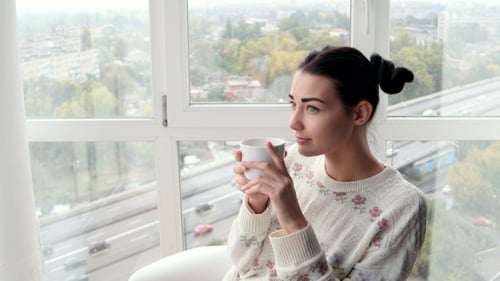 Young Woman Relaxing at Home with City View