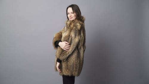 Jeune femme brune montrant un manteau de fourrure