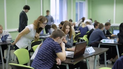 Students at the University on the Exam on Computer Science. In the Large Audience a Lot of People