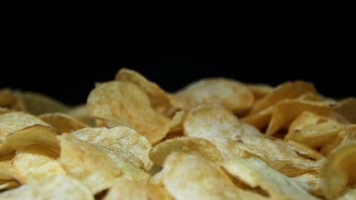 Potato Chips Rotating On Black Background