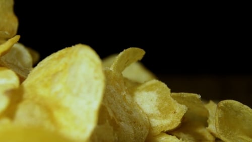Potato Chips Rotating On Black Background