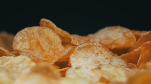 Potato Chips Rotating On Black Background