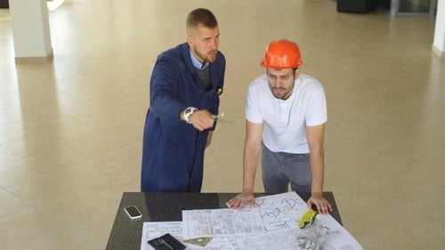 Creative Engineer Coworkers Working on Plan in Hardhat