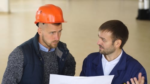 A Team of Construction Workers with Orange Helmets at Work Place in a Factory