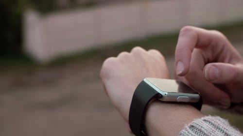 Woman Interacts with Smartwatch Technology Outdoors