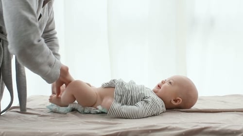 La madre cambia el pañal de su hijo