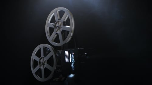 Film Projector with Film Reels Playing in Dark