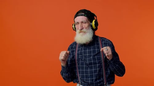 Vieil homme âgé écoutant de la musique sur des écouteurs, dansant, disco, tromperie, s'amusant, gesticulant