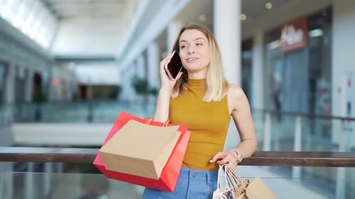 young happy after shopping woman talking on cell in mall.