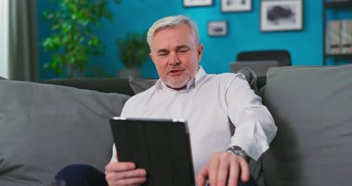 Man using tablet for video call on couch
