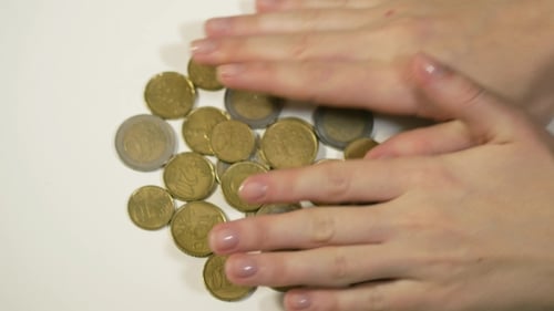 Female Hand Rakes Up Coins