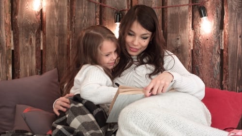 Mother and Child Reading Book Together Indoors