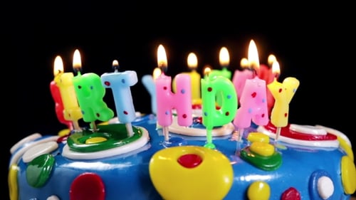 Colorful Birthday Cake with Lit Candles Rotating