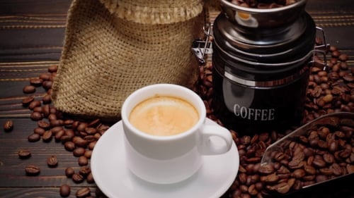Coffee beans and cup on wooden table