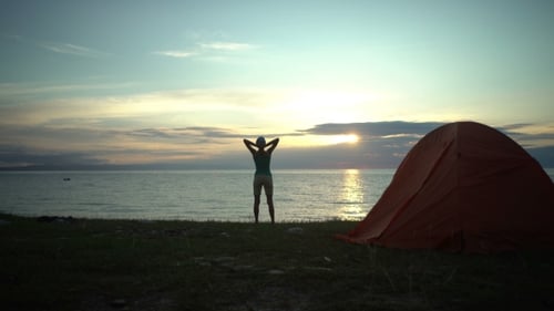 Lone Camper Enjoying Ocean Sunrise Near Orange Tent
