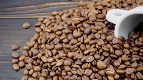 Coffee Beans Piled with Cup on Dark Wooden Surface