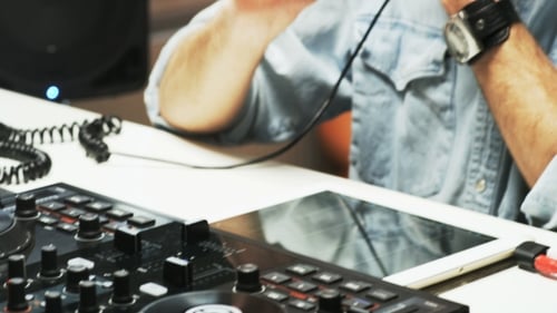 Disc Jockey's Face and Hands While He Changes Settings of the Sound Control System