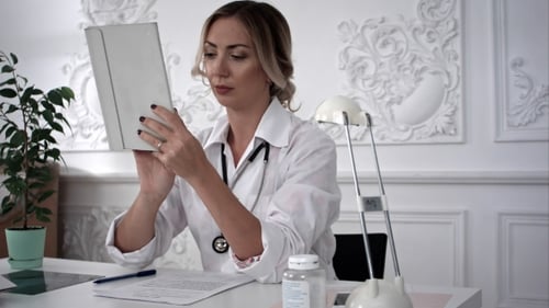 Young Female Doctor Work on Tablet Computer in Office