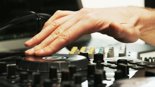 Disc Jockey's Hand While He Changes Settings of the Sound Control System