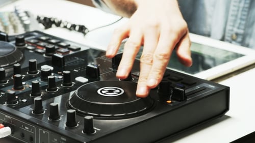 Disc Jockey's Hands and Face While He Changes Settings of the Sound Control System