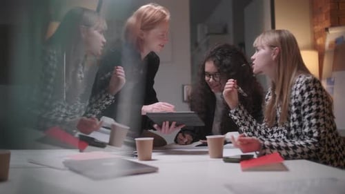 Women Collaborate on Tablet During Business Meeting