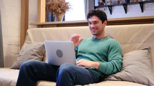 Man Video Chatting on Laptop at Home
